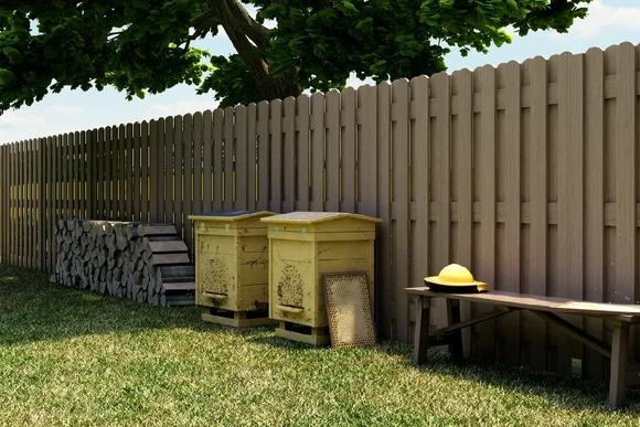 Zwei Bienenstöcke an einem Gartenzaun